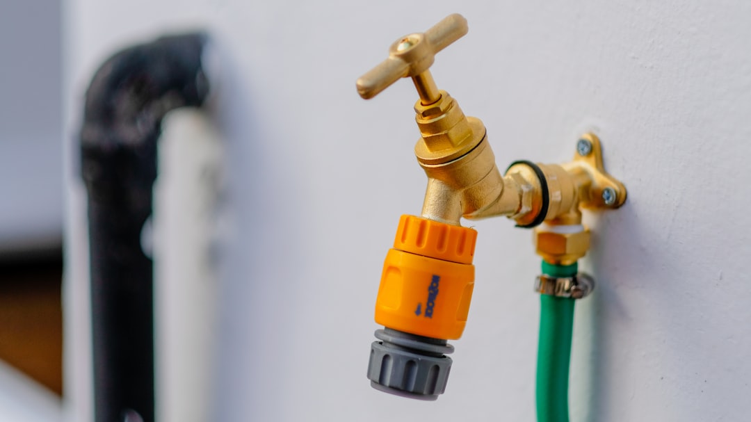 A network engineer inspecting a hardline connector on an outdoor tap