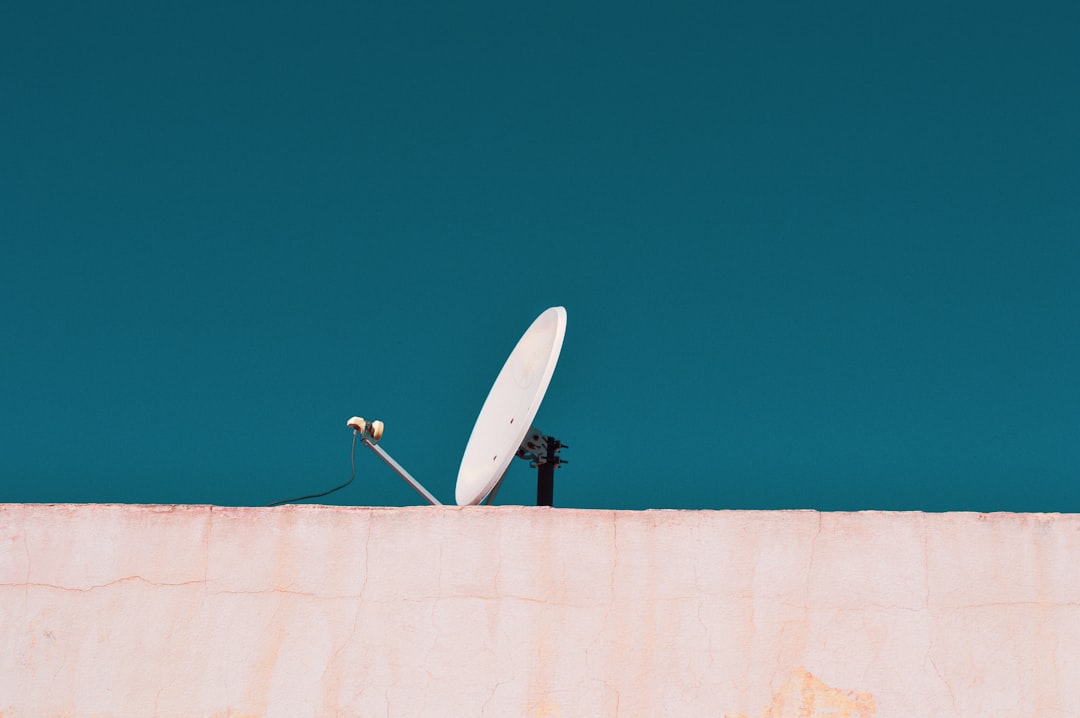 A person connecting an antenna cable to the back of a television