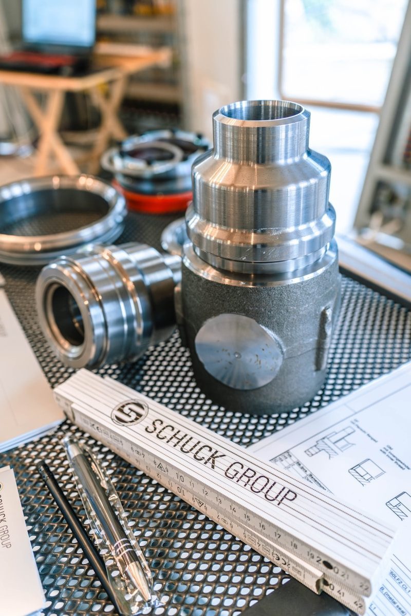CNC rapid prototyping technical drawings and machined metal parts on a workshop bench
