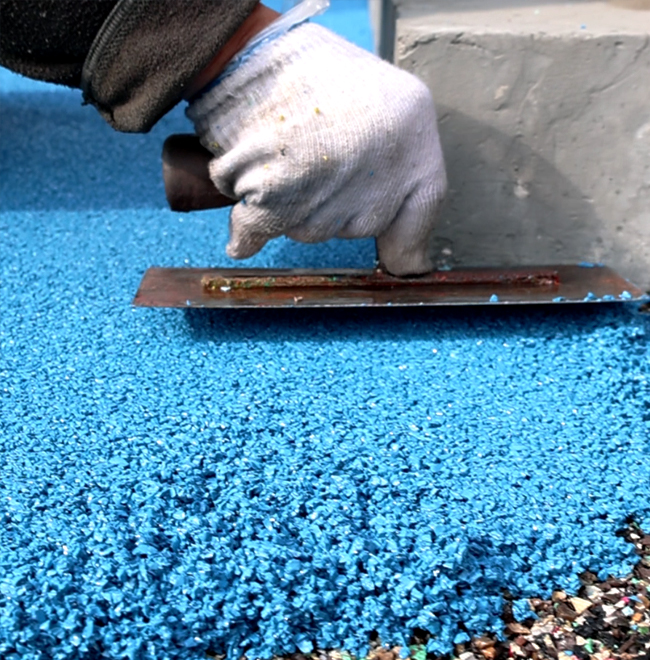 An installer is paving EPDM granules with hands