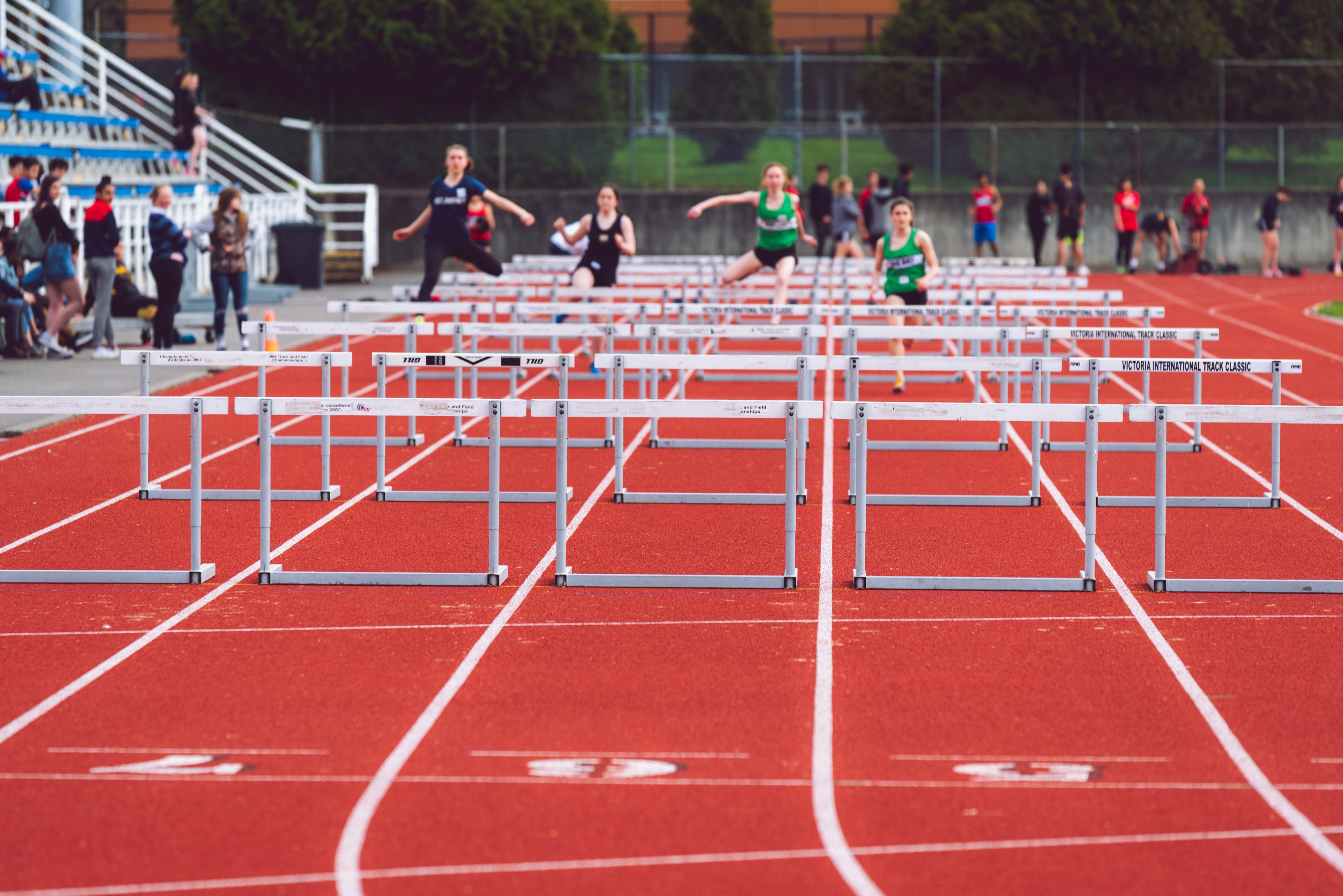 Athletes competing in hurdles on the EPDM granules track