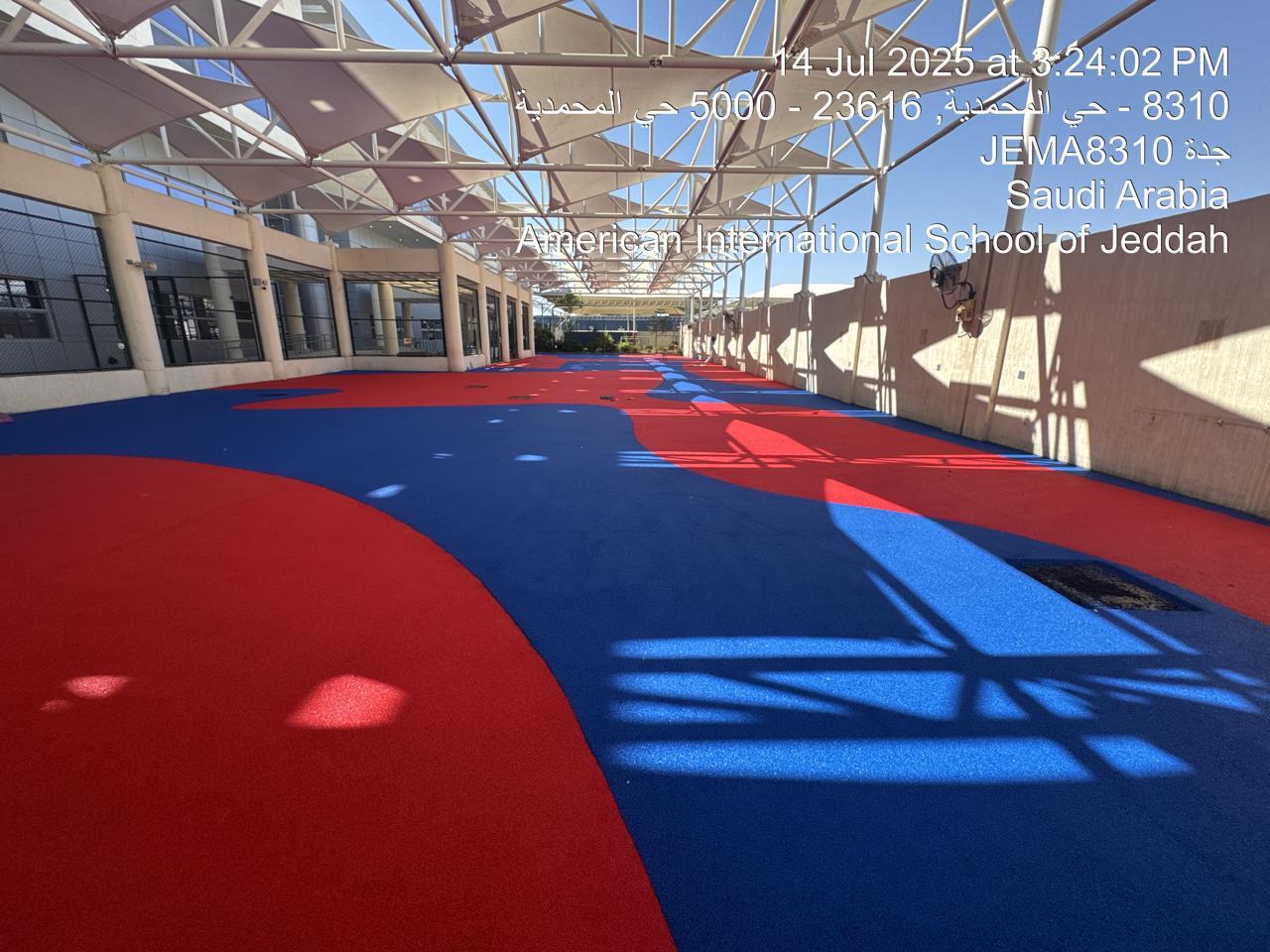Aerial view of the seamless red and blue EPDM playground surfacing at an American school in Saudi Arabia