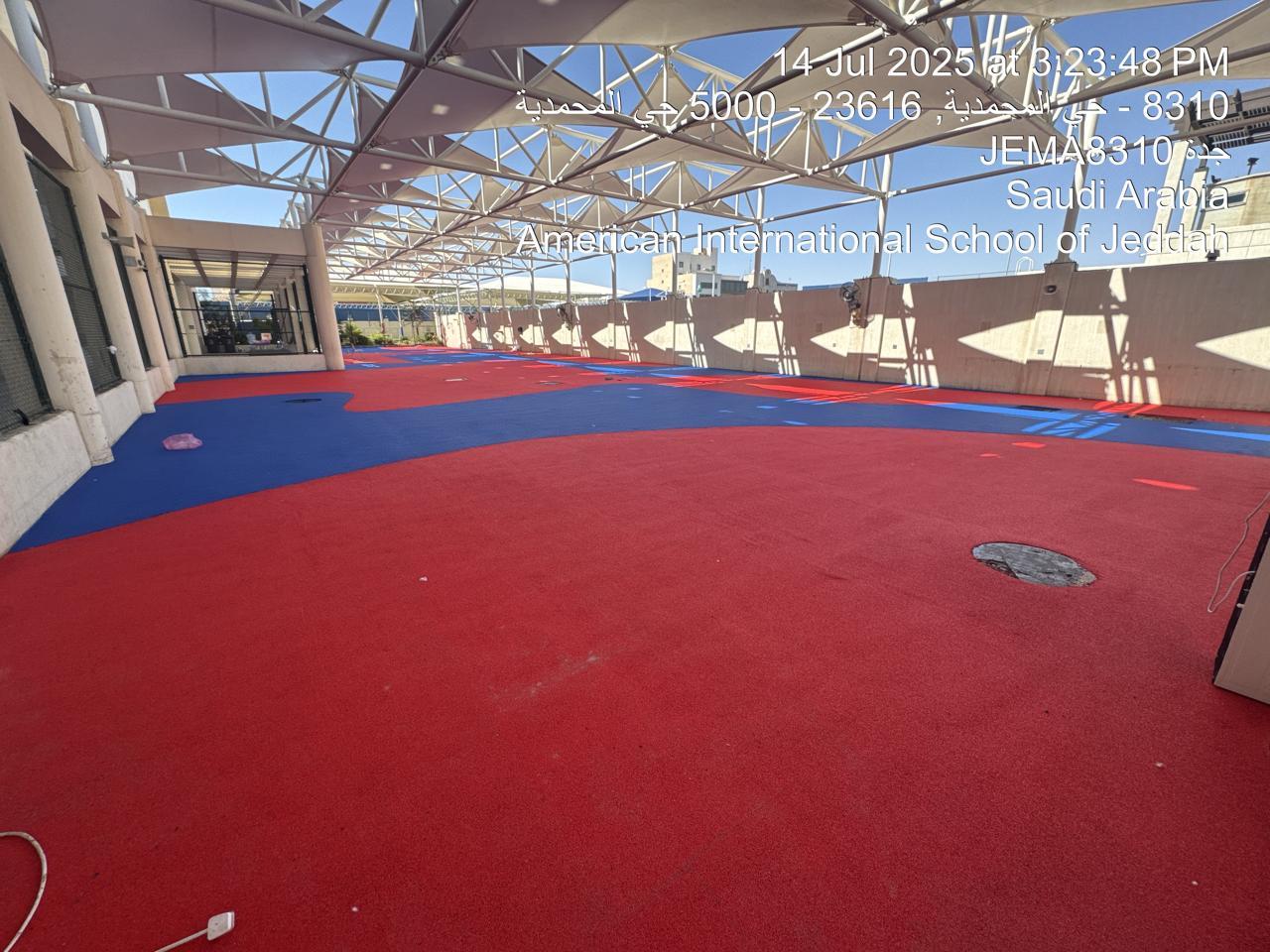 Aerial view of the seamless red and blue EPDM playground surfacing at an American school in Saudi Arabia