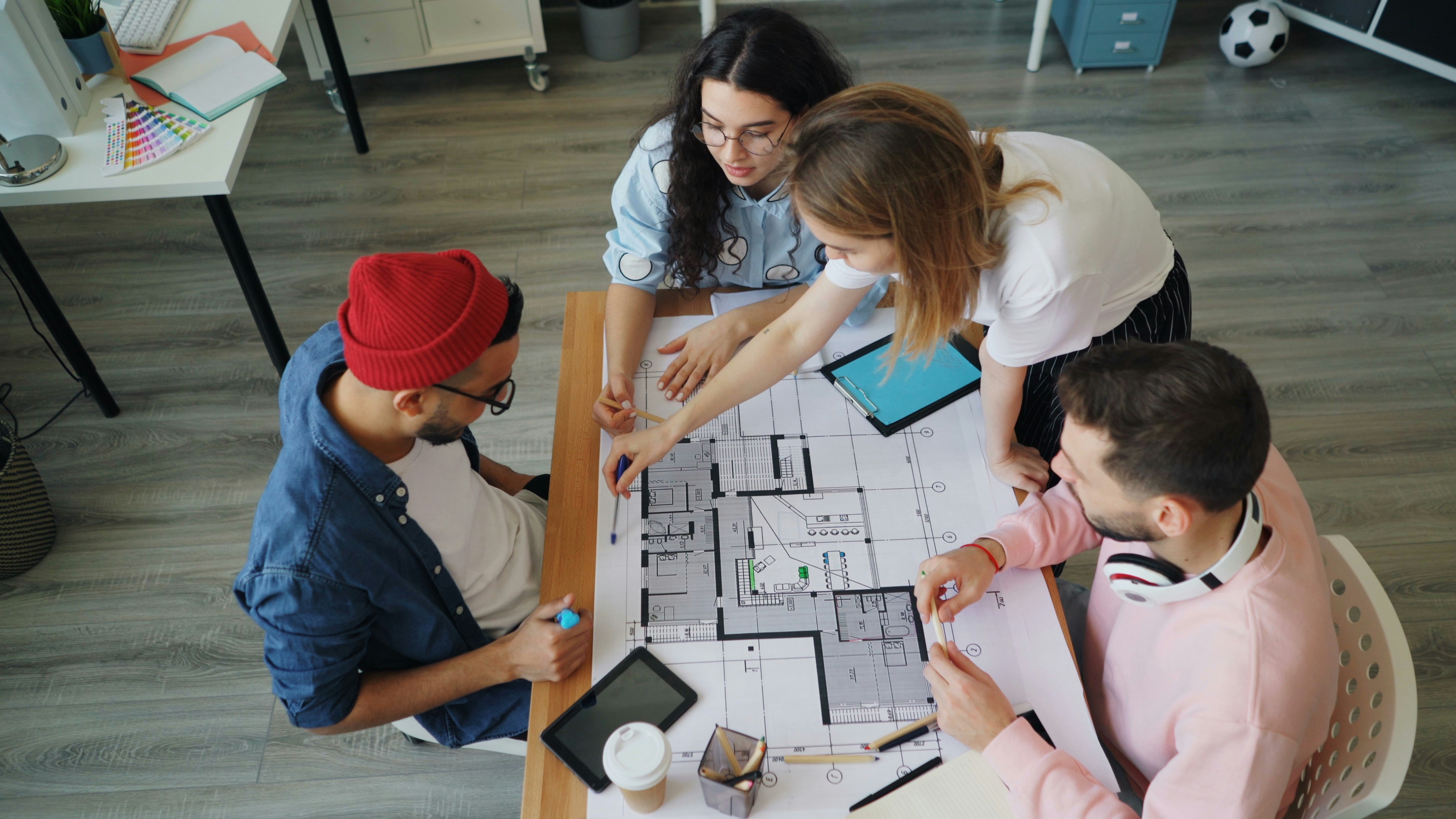 A construction team in a huddle reviewing plans on a tablet