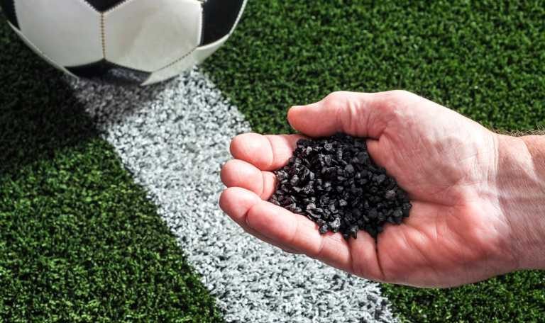 Black SBR Rubber Granules placed above artificial turf fibers