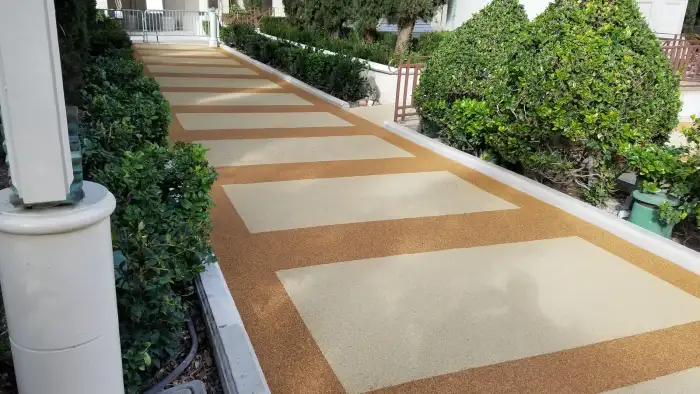 Natural mixed-color EPDM rubber surfacing integrated with residential planting and paving