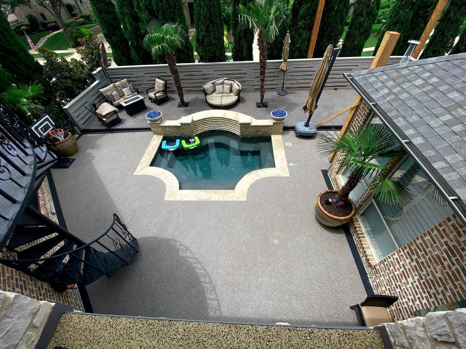 Aerial view of a Rubaroc pool surround integrated with a home garden