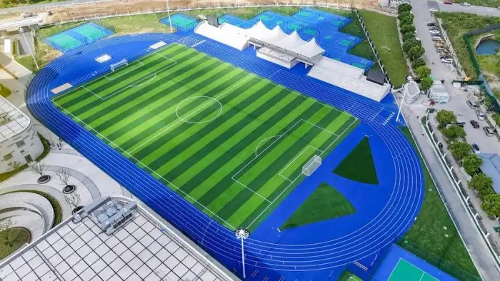 Blue EPDM running track surfacing alongside adjacent outdoor sports courts