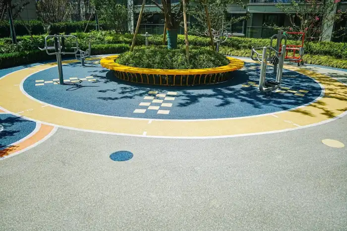 Recreational EPDM path in blue, yellow and light gray beside outdoor fitness equipment