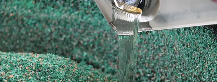 PU binder being applied to EPDM granules to form a bonded surface layer