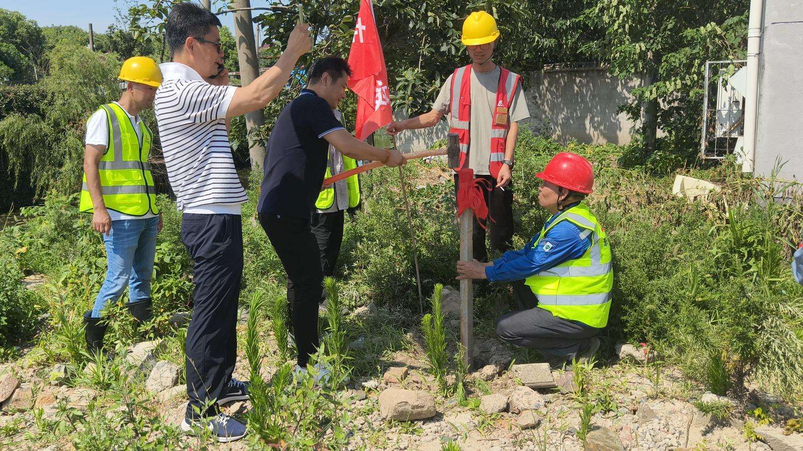Senior leaders strike the ceremonial post during the Quanshun Webbing pile driving ceremony