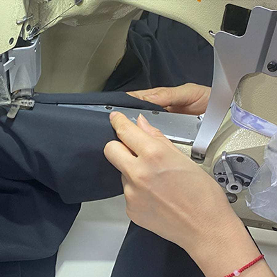 Ohsurewear operator conducting an in-line sewing quality inspection