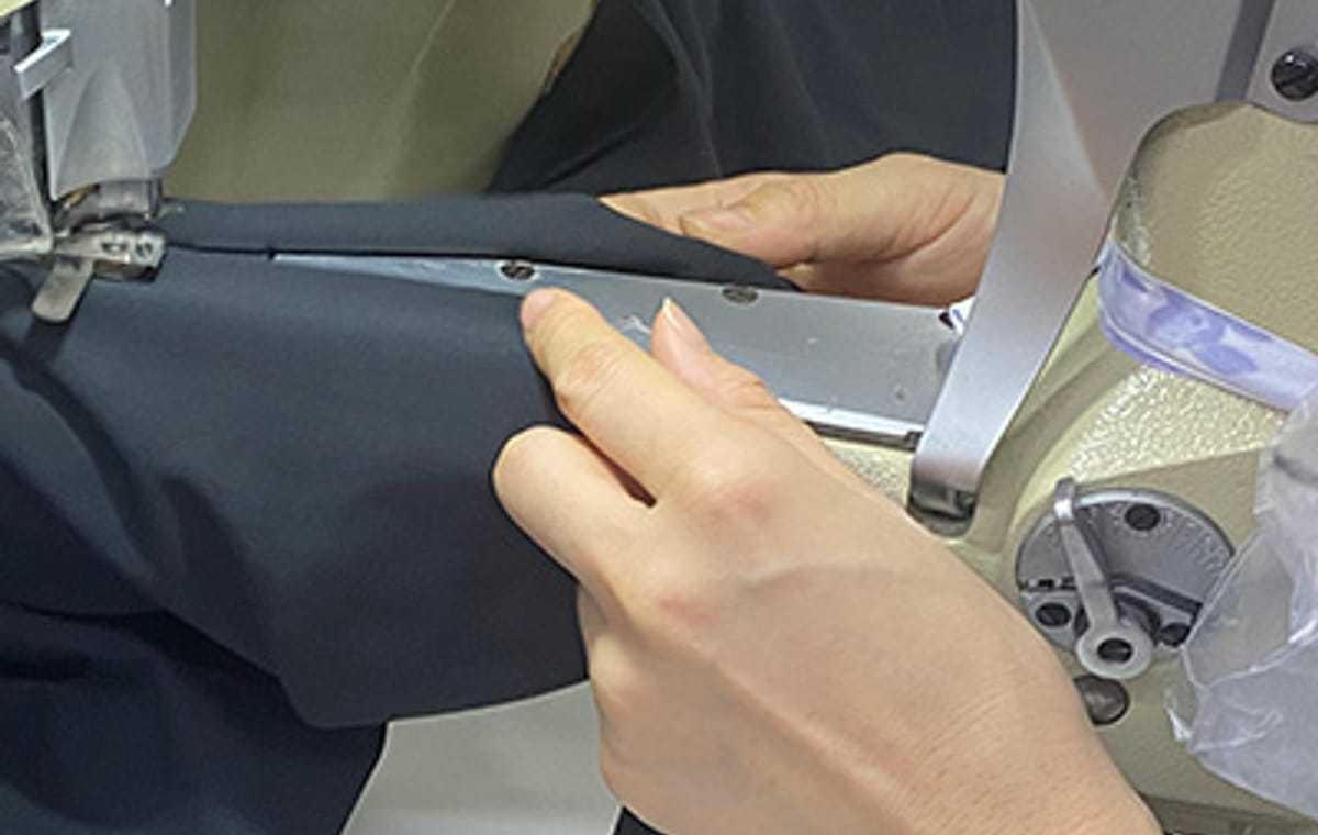 Ohsurewear operator conducting an in-line sewing quality inspection