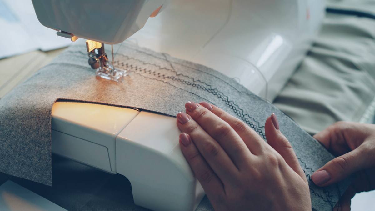 Close-up of fabric being sewn on a garment machine
