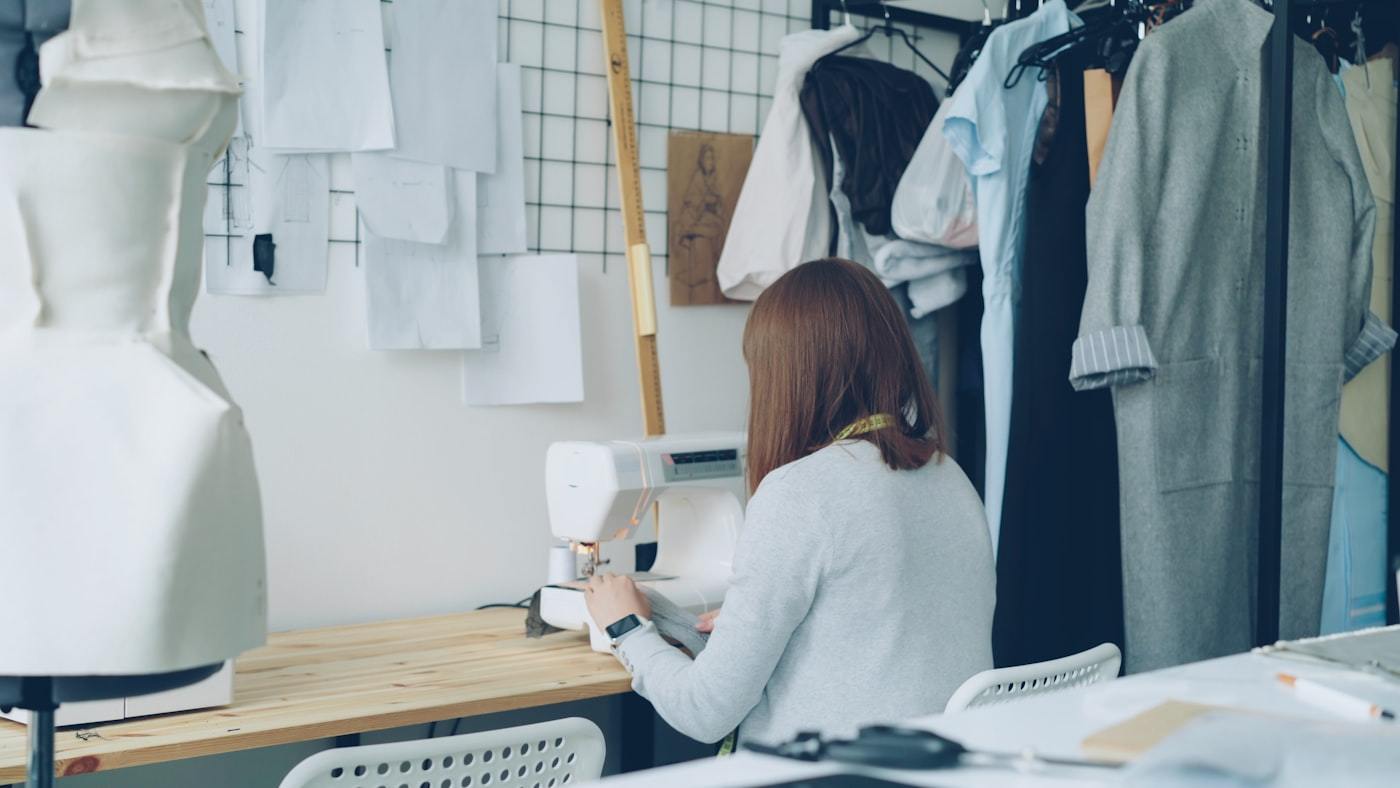 Clothing designer sewing a garment in a fashion studio