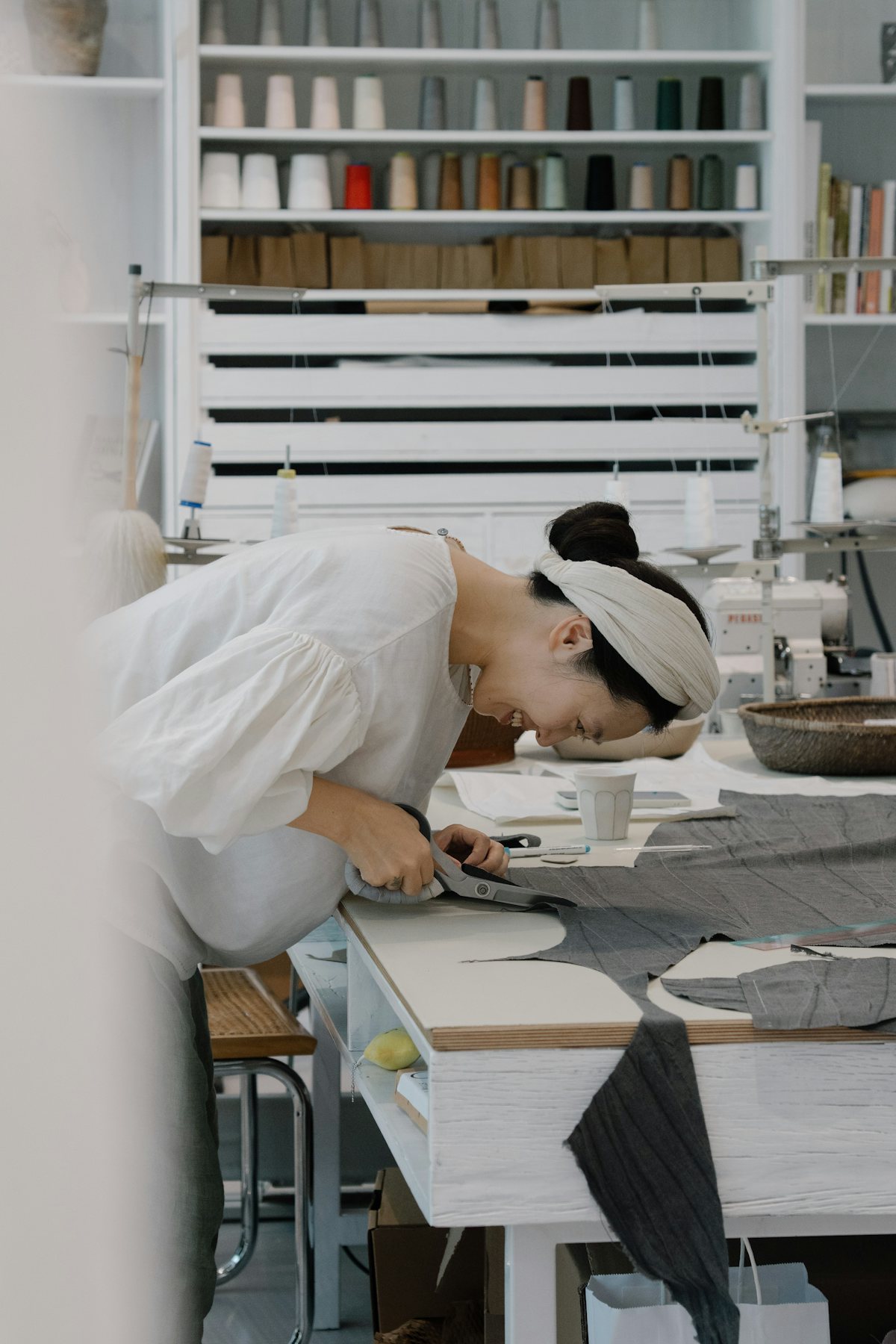 Woman cutting fabric at a sewing table
