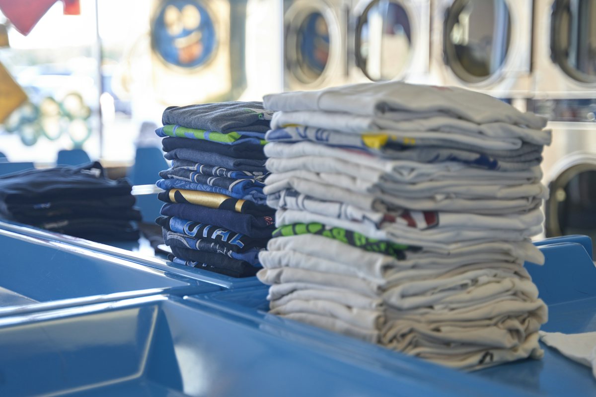 Stacks of folded shirts on a laundry worktable