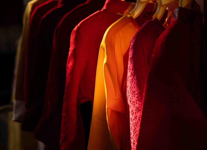 Row of colorful hoodies and shirts hanging on a retail rack