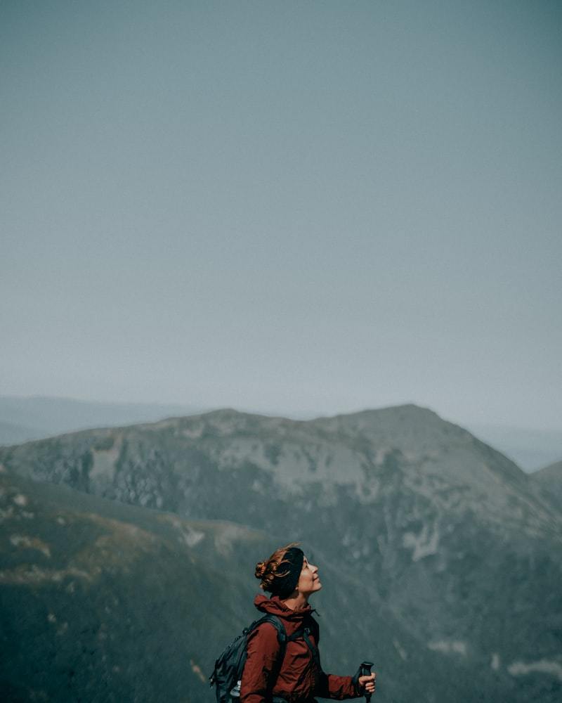 Man in black jacket and backpack standing on mountain