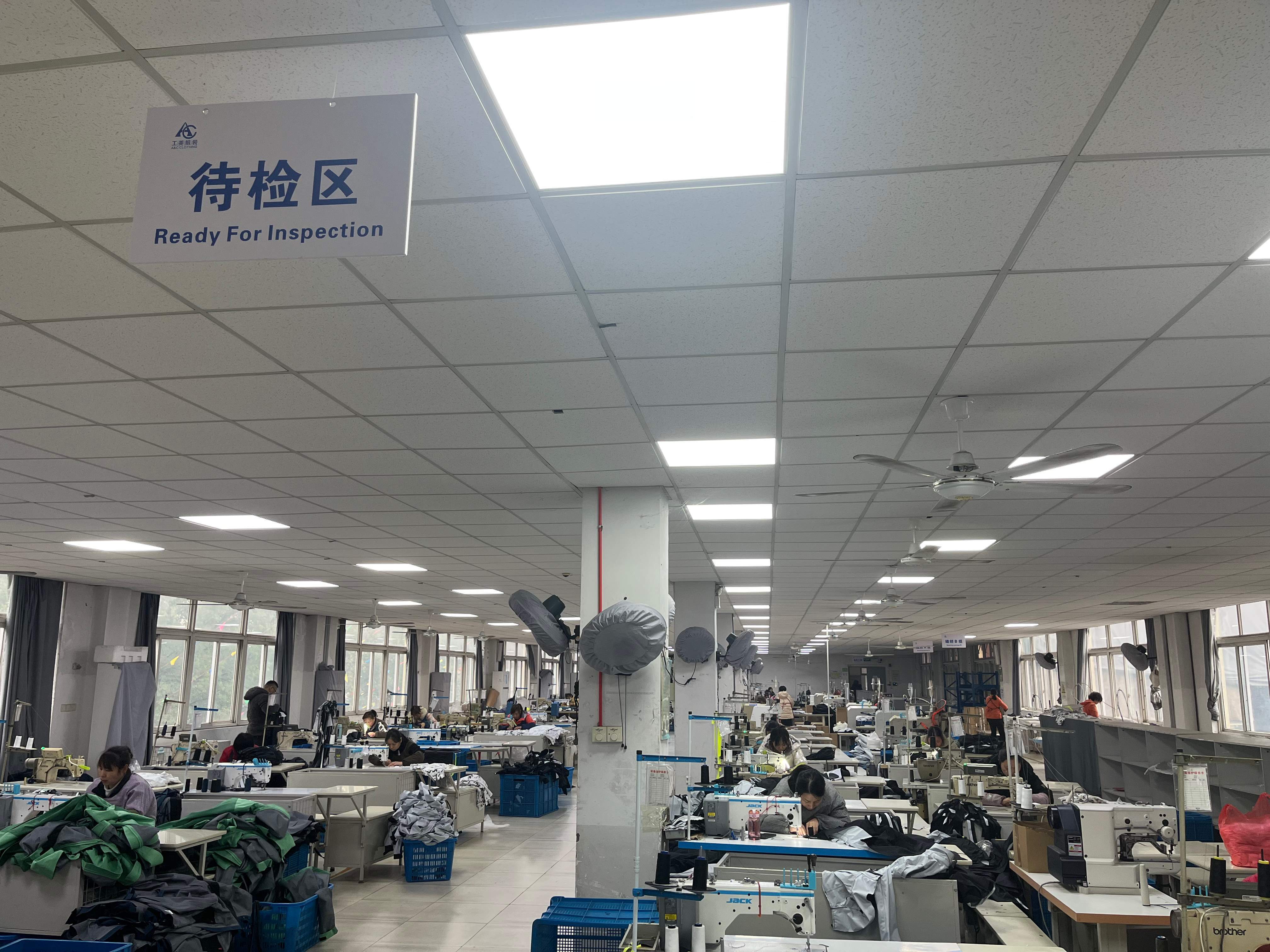 Factory workers sewing outdoor jacket samples