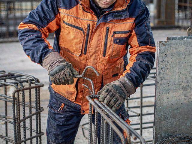 Steel fixer in reinforced work jacket working with rebar