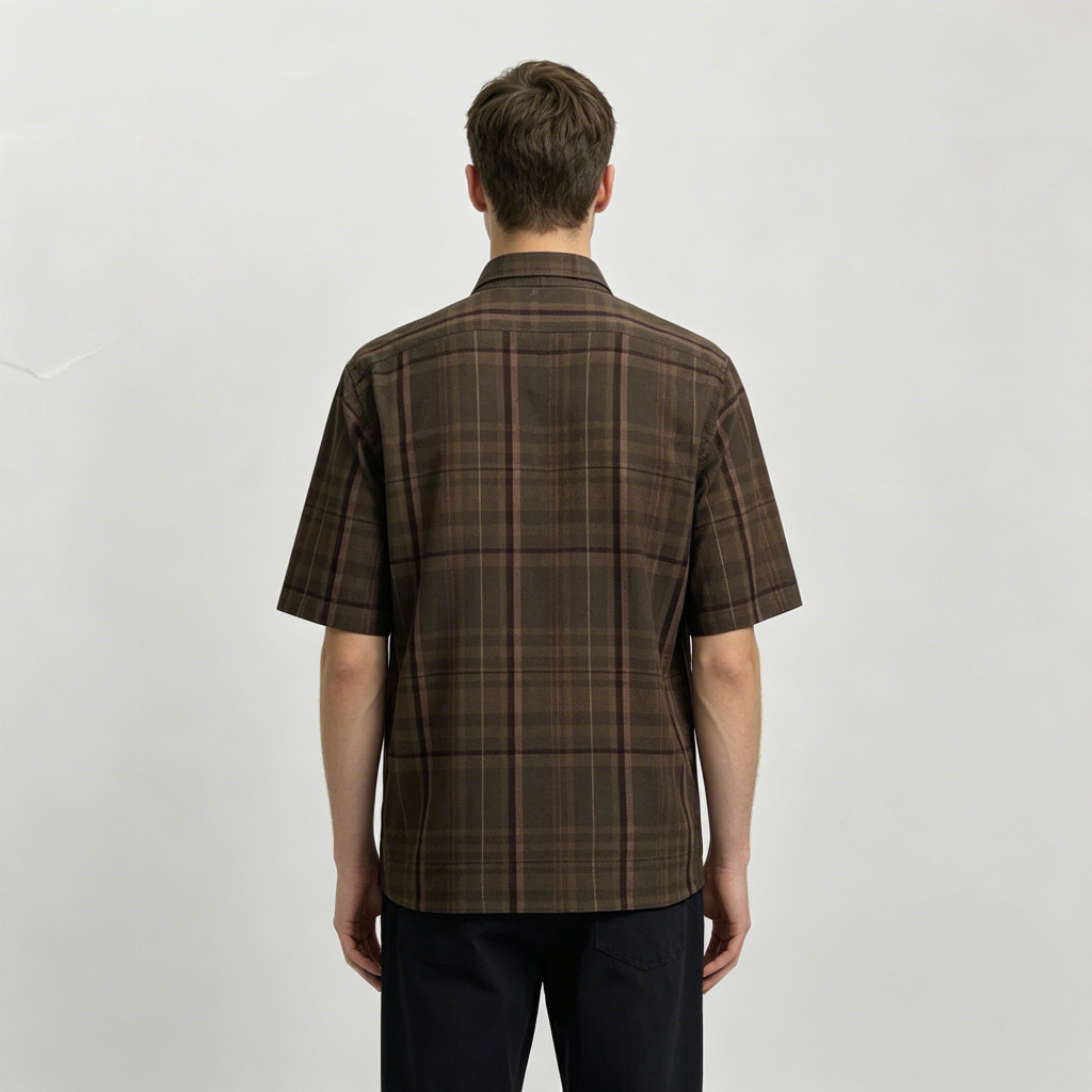 Man wearing brown windowpane check shirt in outdoor scene