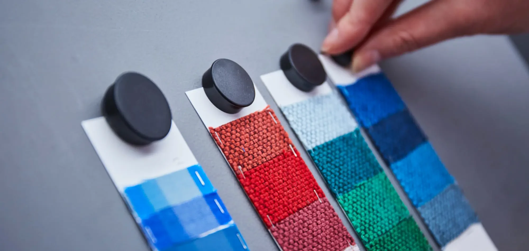 Fabric swatch cards in seasonal colourways pinned on the development table