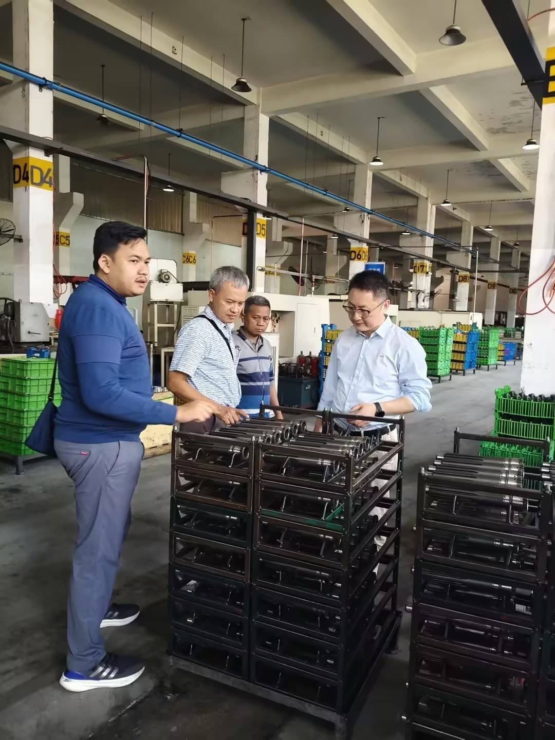 Visitors observing quality inspection and measurement of finished gears.