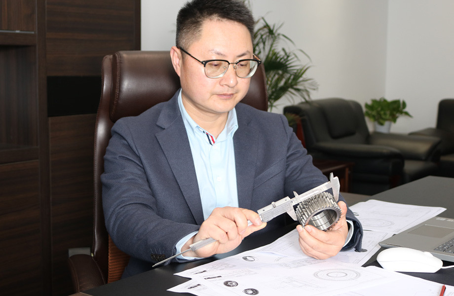 Engineer checking a gear against a drawing
