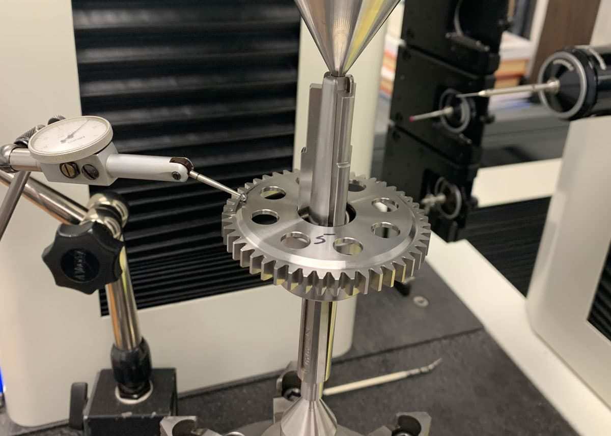 Dial indicator checking runout on a mounted gear