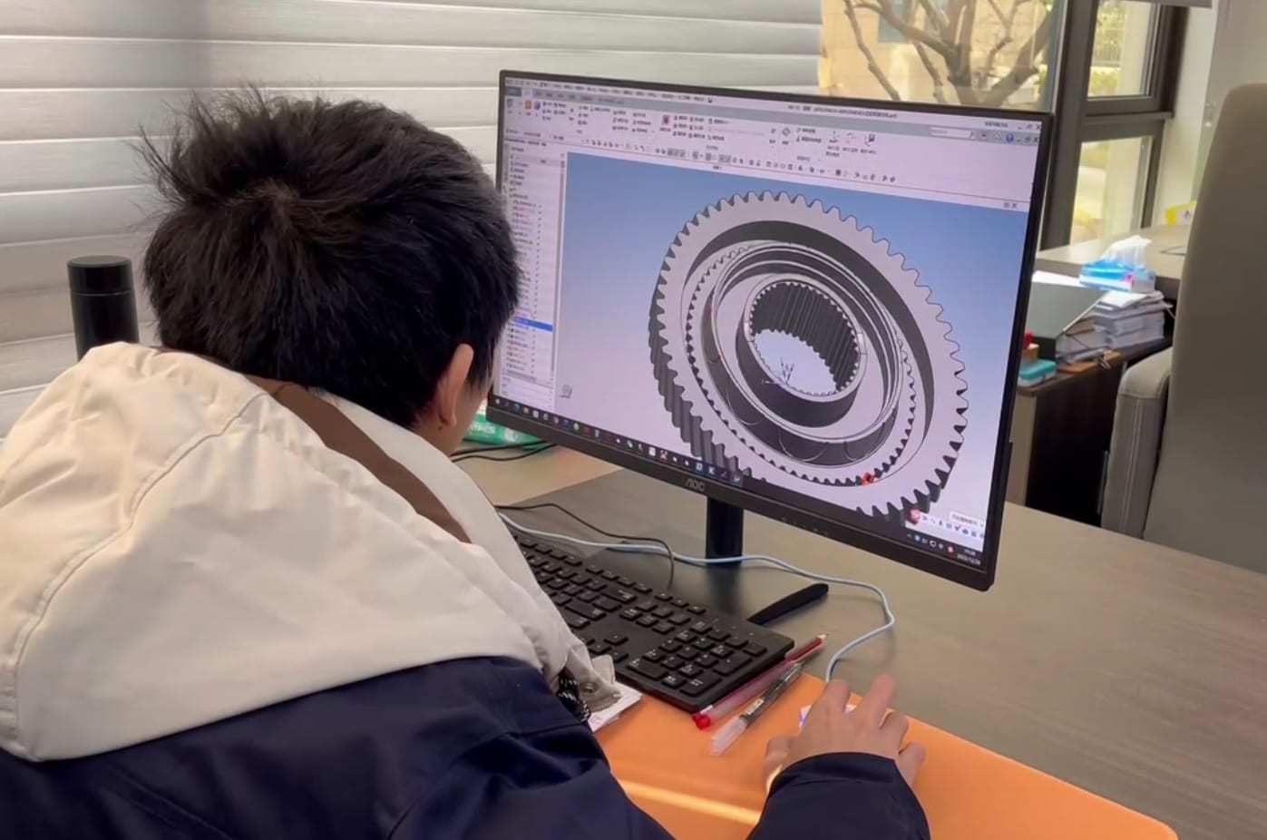 Engineering team reviewing a mechanical design on screen