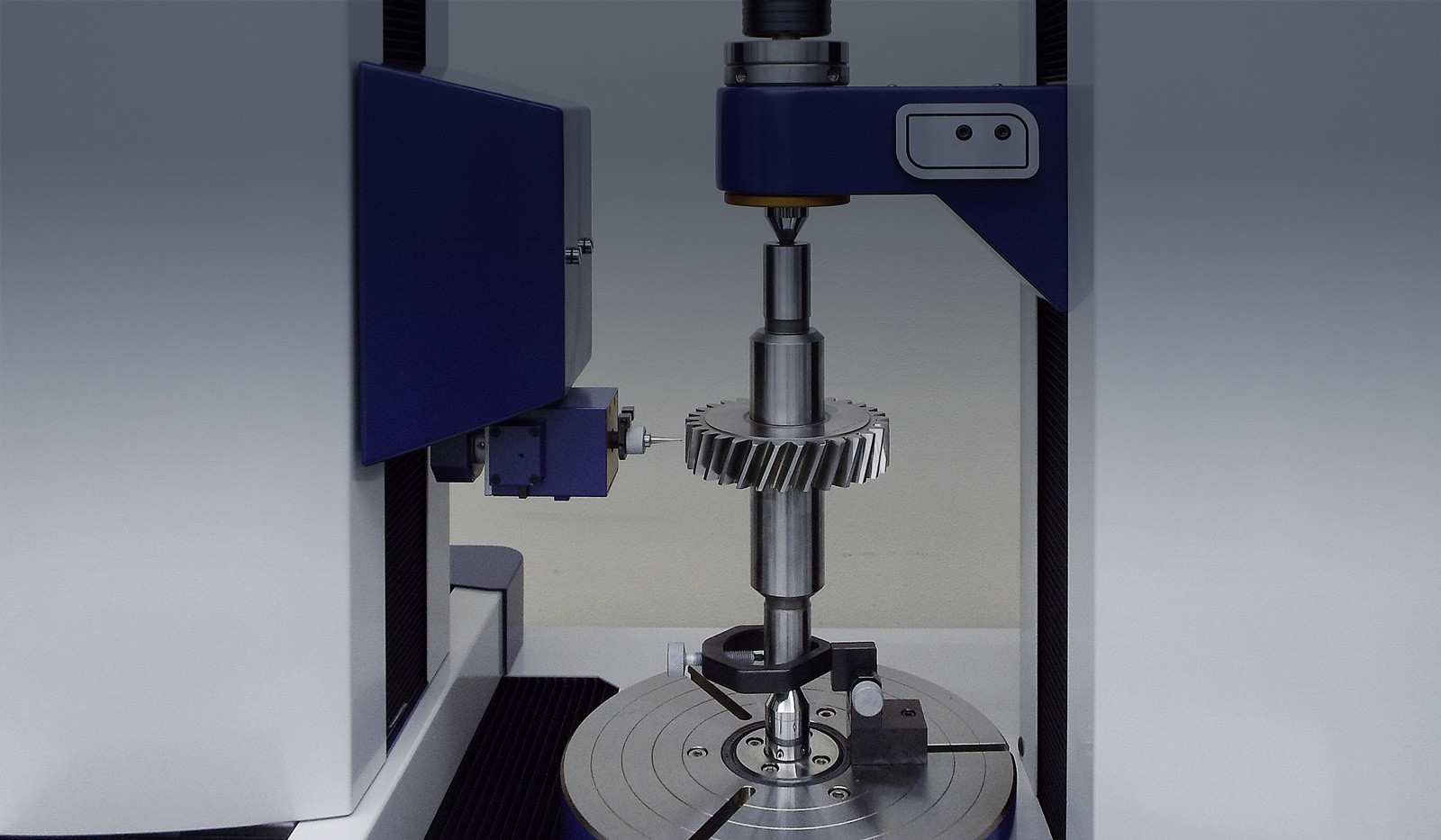 Precision machine checking a metal gear.