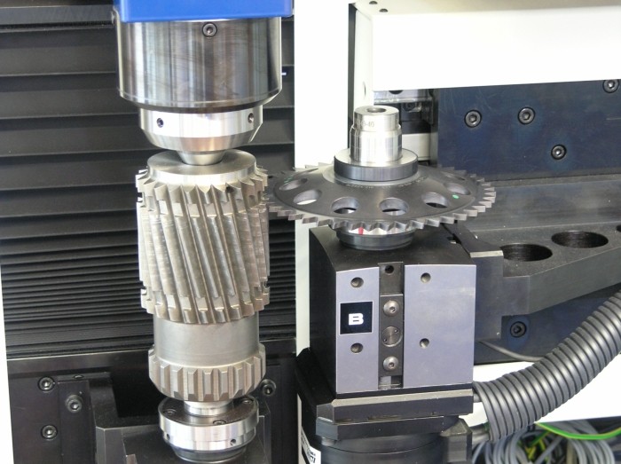 Gear flank analyser measuring a gear between precision fixtures.