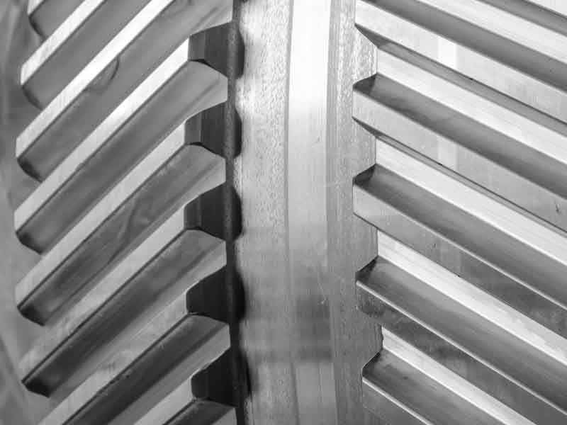 Two helical gears meshing with polished tooth flanks.