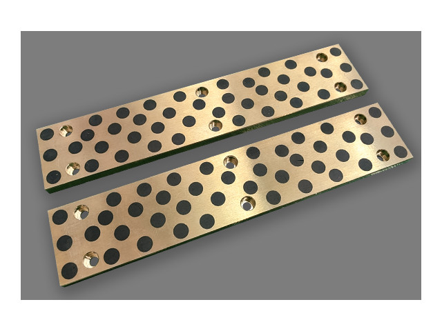 Self lubricating ram guide plate