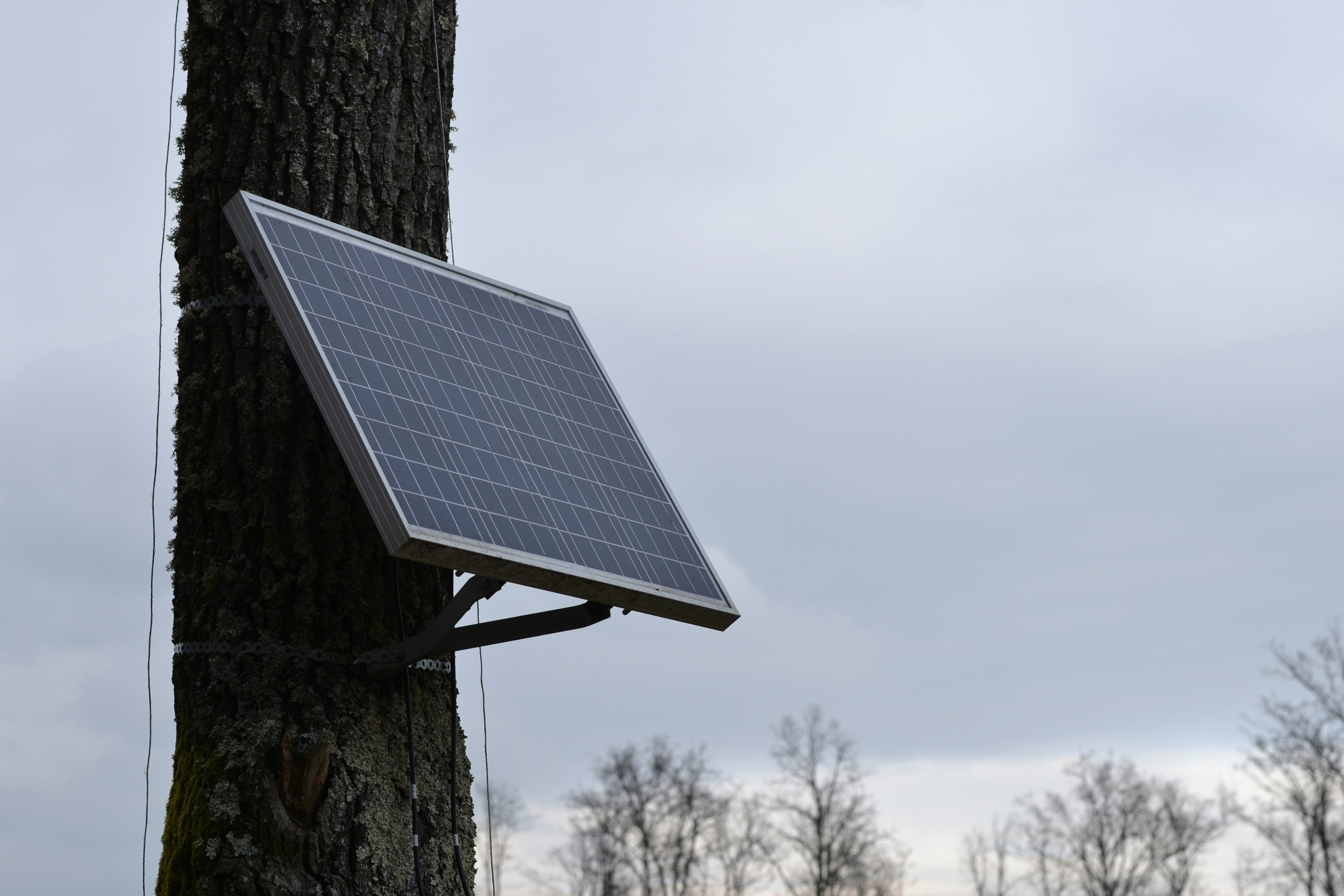 Diagram showing how a solar panel captures sunlight to power a security camera and charge its battery.