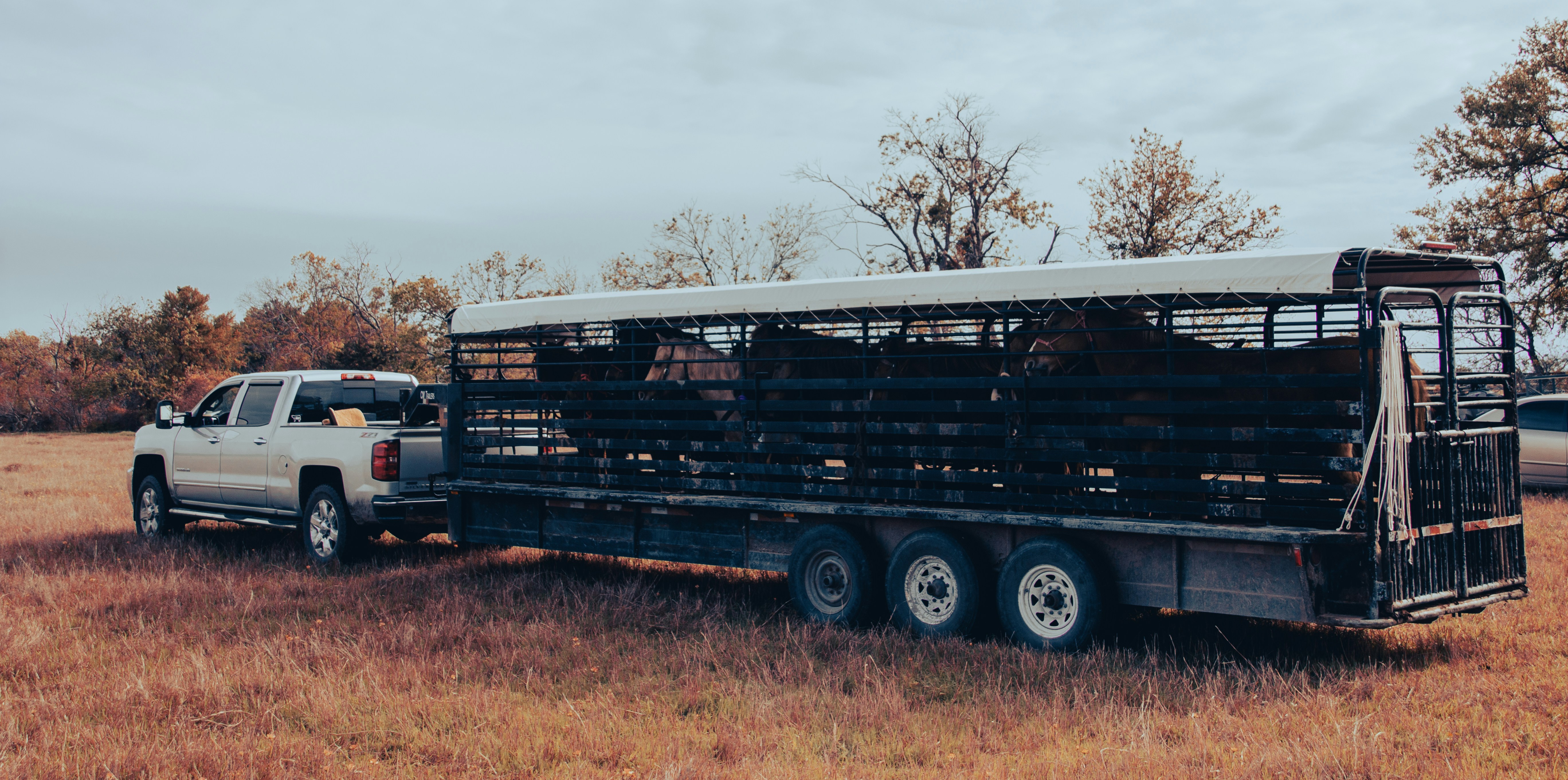 A truck with a hard-folding tonneau cover towing a fifth-wheel trailer