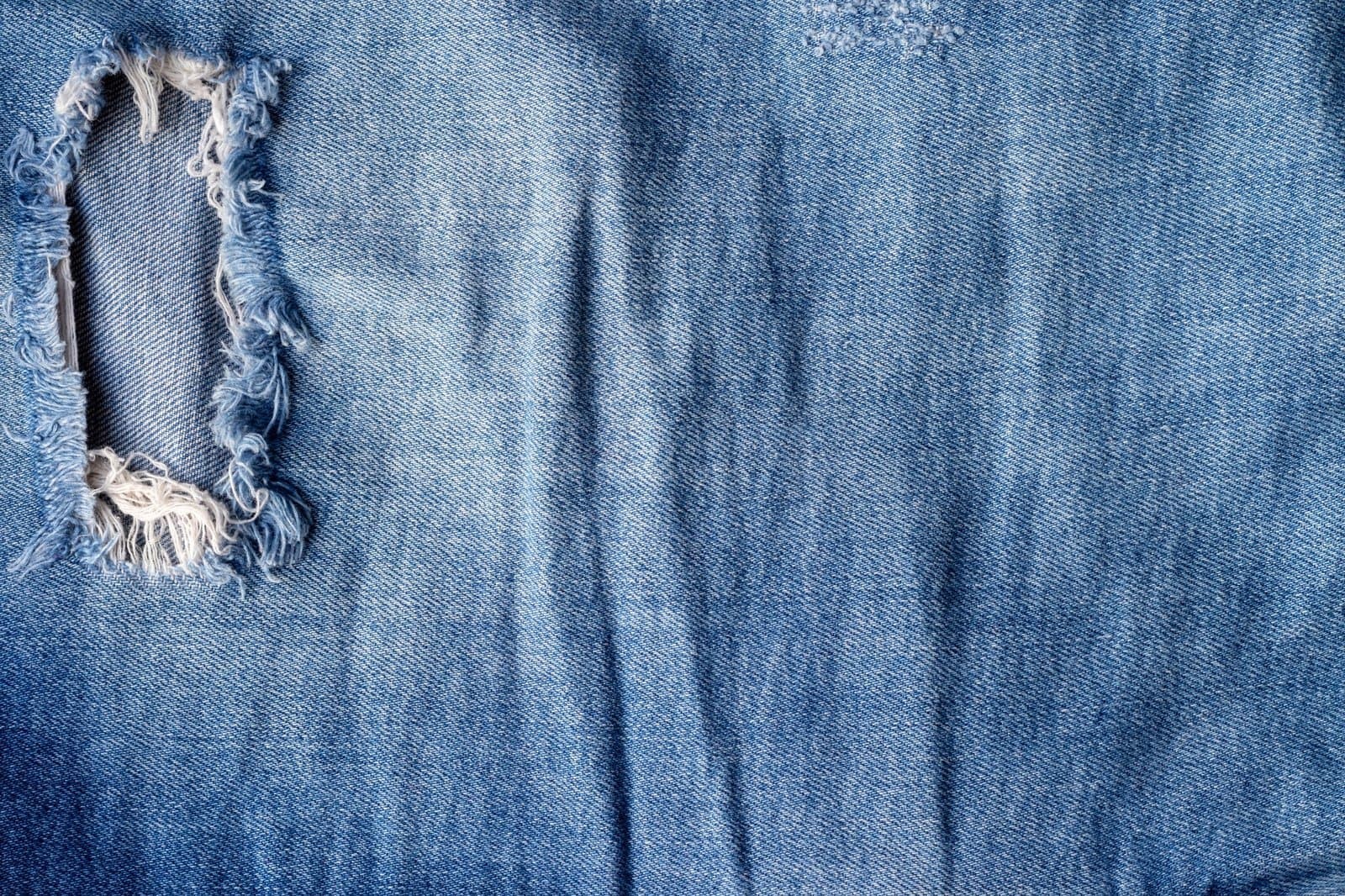 blue-torn-jeans-fabric-texture-distressed-denim-with-hole-and-seam-background