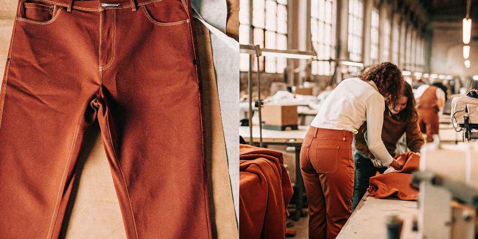 A small, dedicated team in a meeting room, focused on a single pair of jeans, contrasting with a massive, impersonal factory floor.