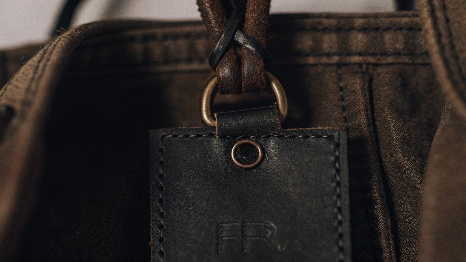 Look for a specific tag or label that explicitly states the garment is "FR" (Flame Resistant) and lists the safety standards it meets. 