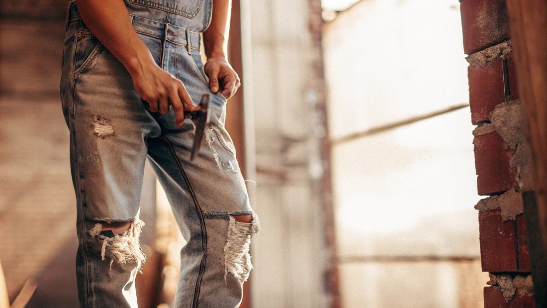 To distress your jeans at home, gather basic tools—scissors, sandpaper, a razor blade