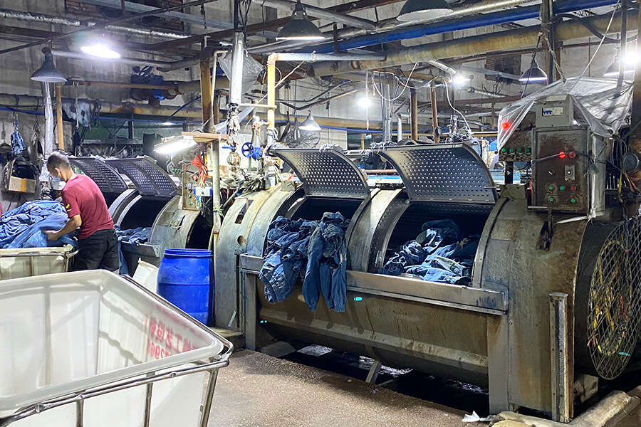 How do factories perform the acid-wash process to make acid-wash jeans?