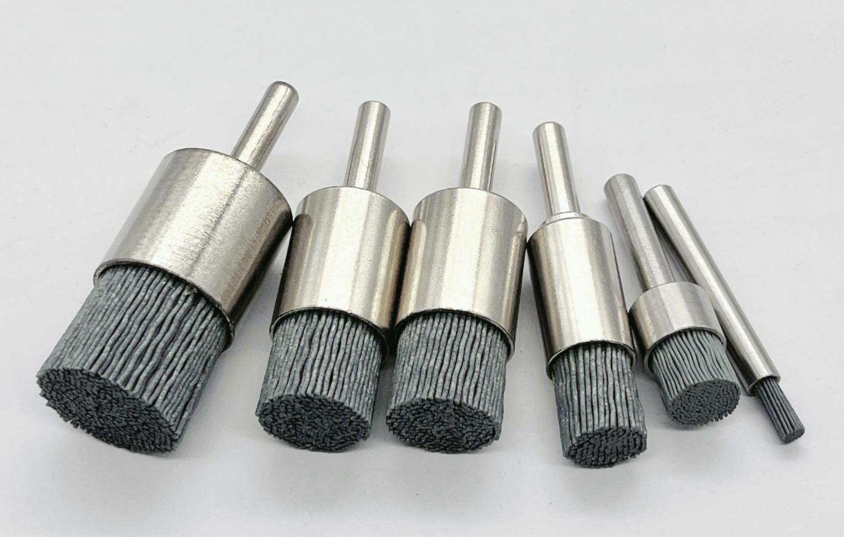 Diagram showing the components of an abrasive brush: hub, filaments, and abrasive grit