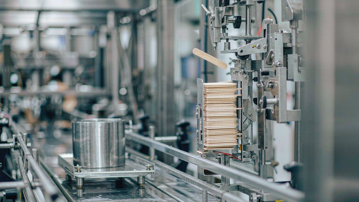 Bare wooden sticks stacked in the magazine of a high-speed ice cream stick inserter line
