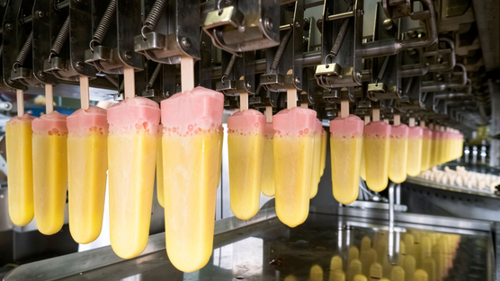 Bare wooden sticks stacked in the magazine of a high-speed ice cream stick inserter line