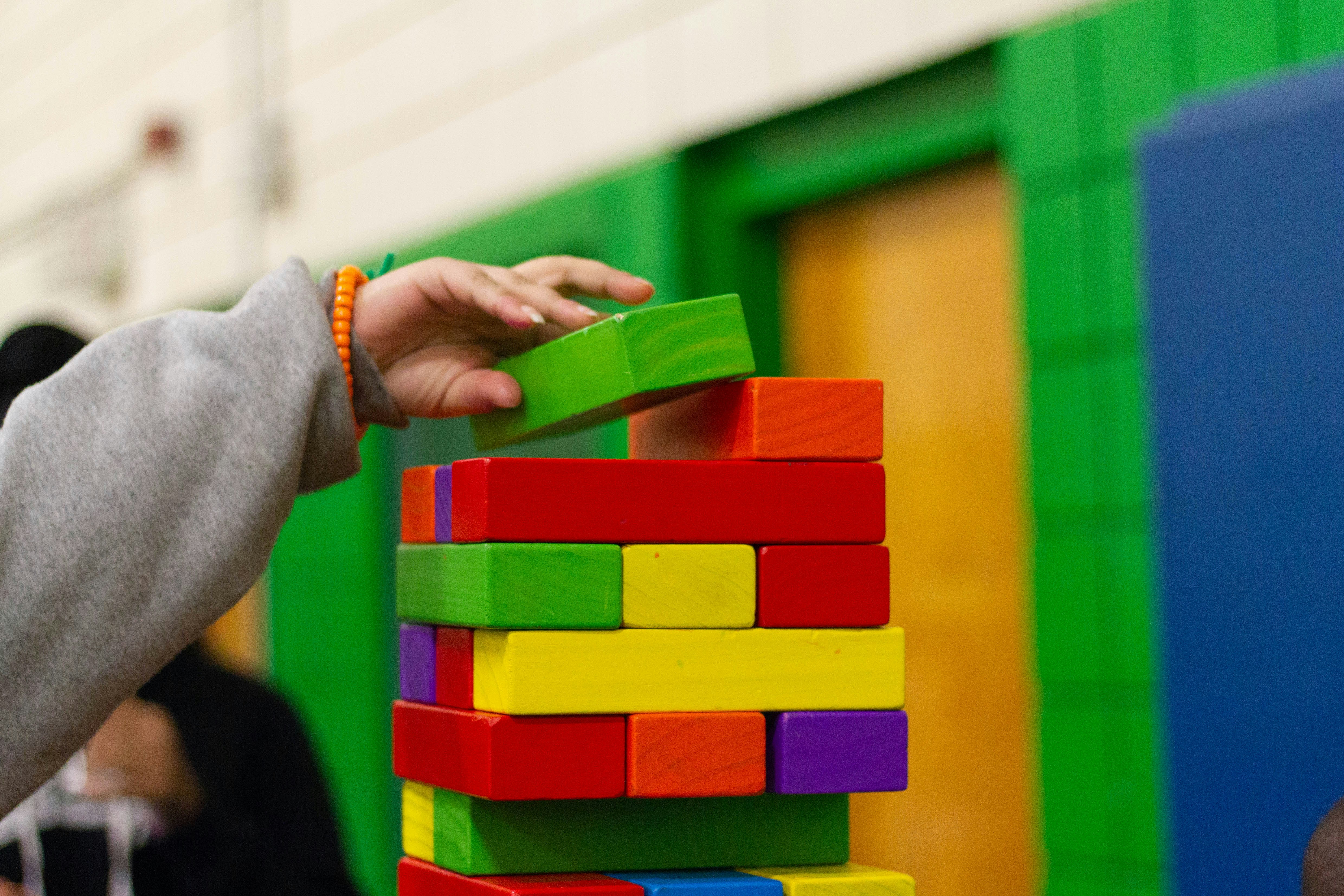 Child playing with sustainable wooden toys A child playing with colorful wooden building blocks