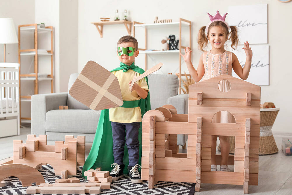 Children role-playing with a wooden block castle