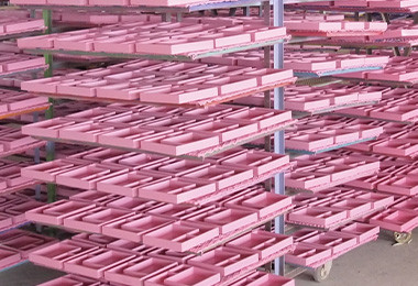 Freshly painted wooden toy components drying on racks before packing at Forestoy