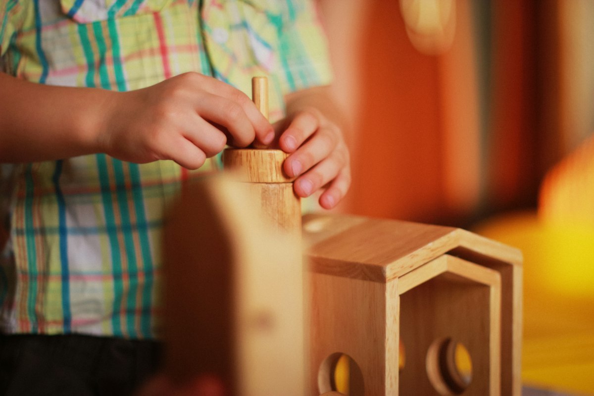 Child playing with a wooden stacking toy