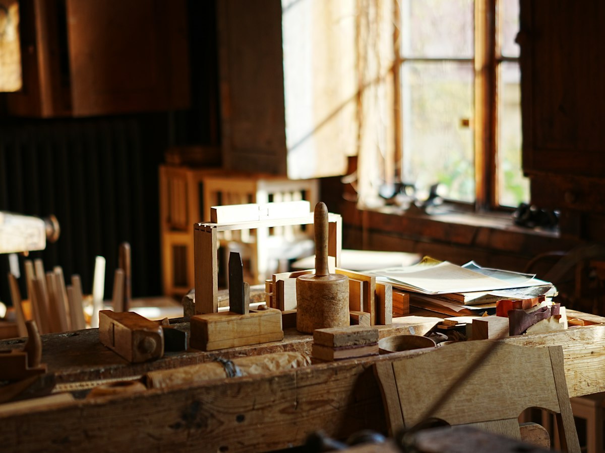 Woodworking tools on a workbench in a sunlit wooden toy workshop